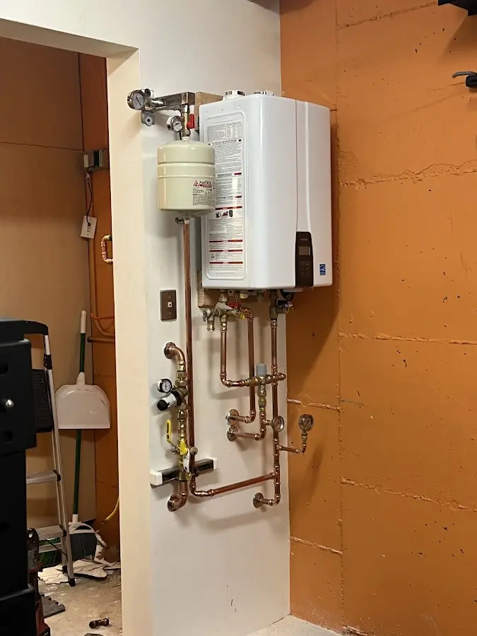Plumbing technician inspecting water heater connections in Woolwich